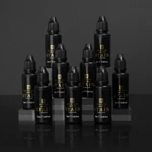 Brow Code Stain Hybrid Dye full collection displayed in a tiered arrangement, featuring 10 professional-grade 15ml bottles for brow tinting in multiple shades