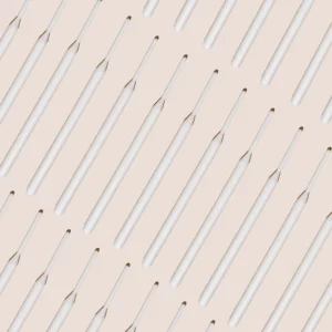 Brow Code Tinting Sticks 25-pack displayed in a diagonal pattern on a beige background, featuring sleek white sticks for precise brow application